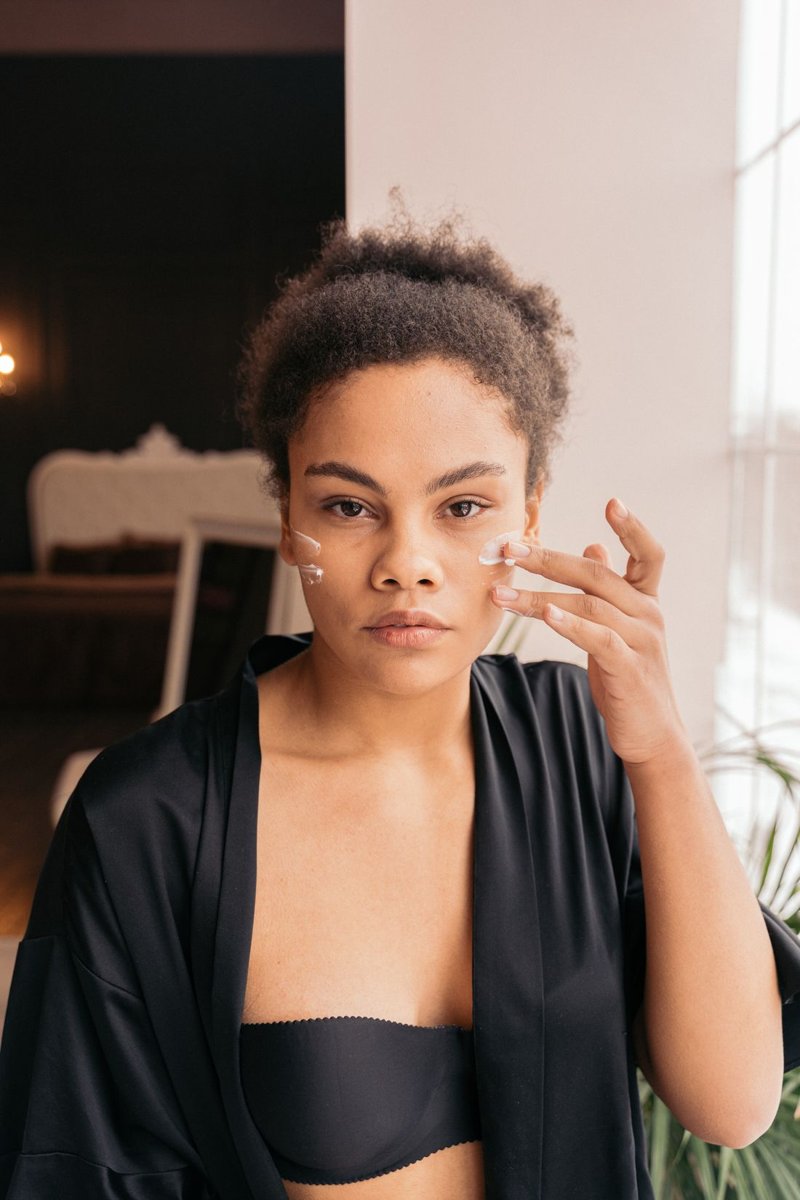 A woman applying facial cream