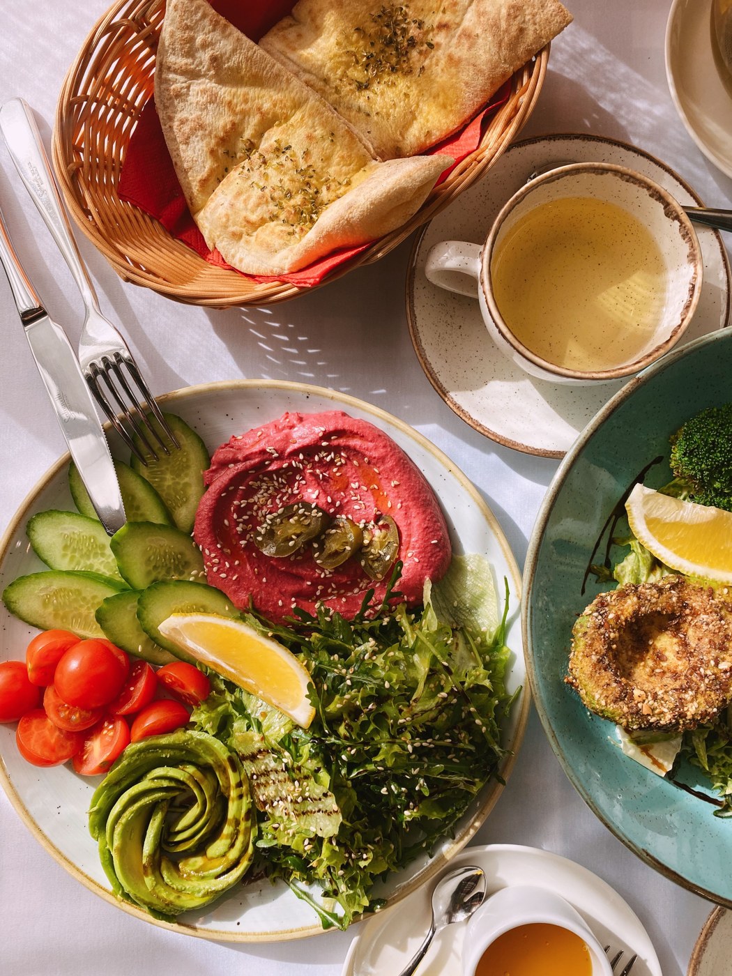 A real meal of hummus, vegetables and bread arranged on a dining table
